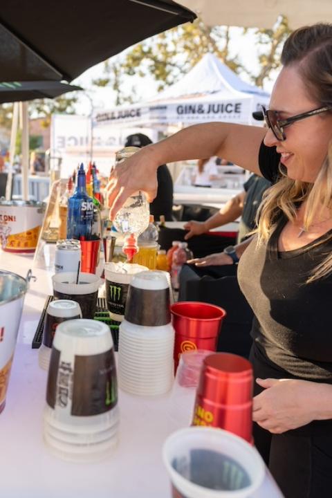 A bartender at a University of Southern California football game pours a drink into a Better for All cup. 