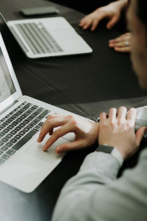 A person typing on a laptop. 