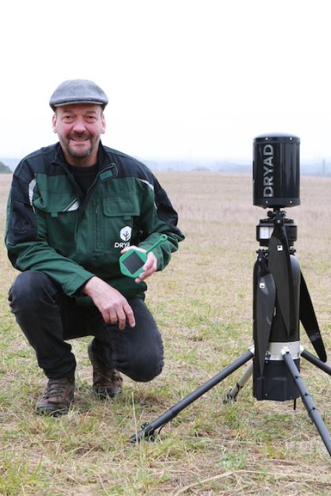 Dryad Networks CEO Carsten Brinkshulte holds a Silvanet wildfire sensor next to a Silvaguard drone that responds to wildfires.
