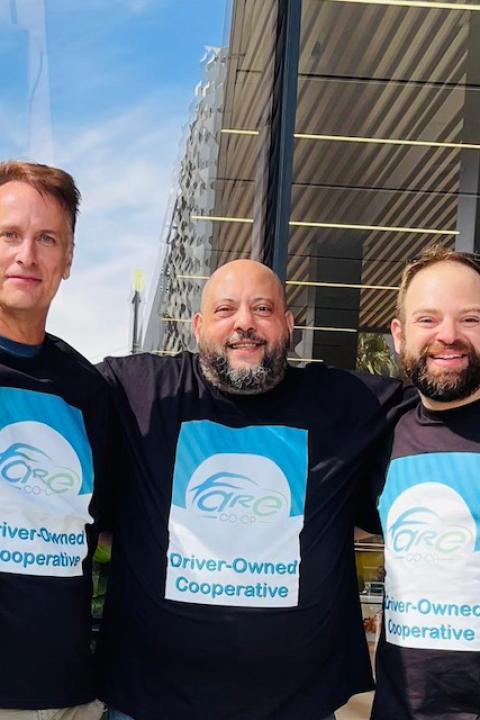 Ivan Olivo, AJ Attia and Danny Golnik stand together in front of the Uber headquarters sign in Fare Co-op t-shirts.