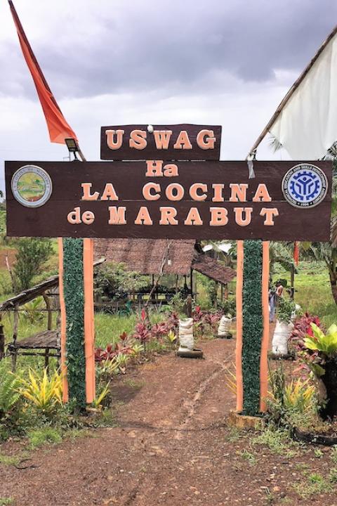A wooden arch at the entrance to the agricultural cooperative La Cocina De Marabut, which advertises its name, in Barangay Osmeña, the Philippines.