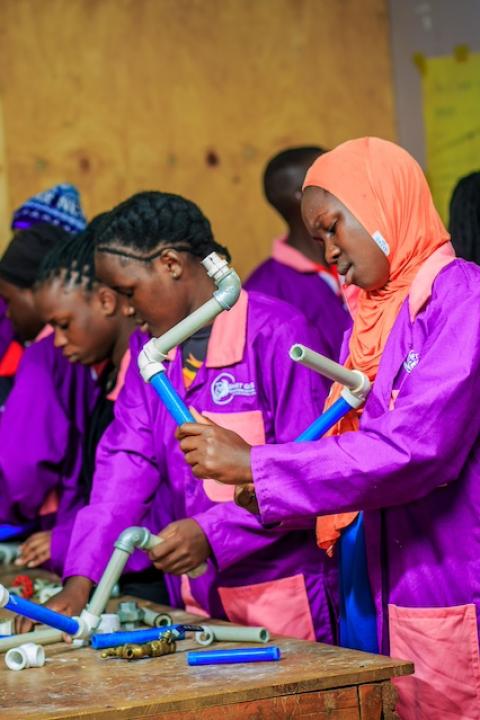 Smart Girls Uganda participants working with piping. 