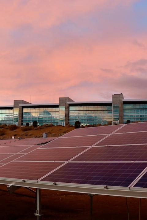 Solar panels in front of a building — climate reporting