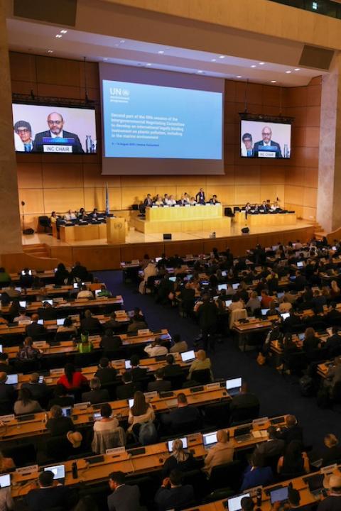 Negotiators sit in a large auditorium for the opening session of the negotiations for the global plastic pollution treaty.