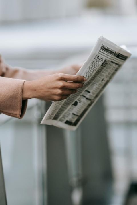 A person reading a newspaper. 