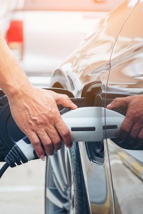 man charging an electric vehicle — EVs and the power grid 