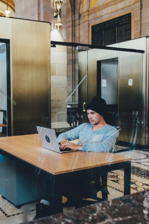 man working on laptop in shared office space - employee engagement