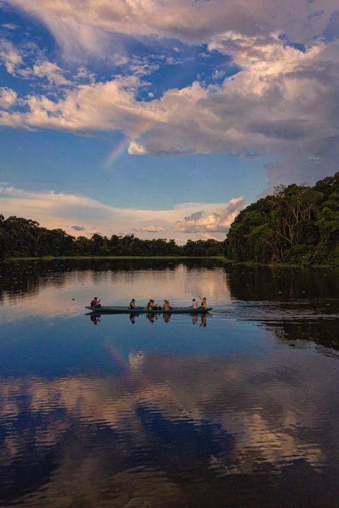 people on boat in amazon rainforest