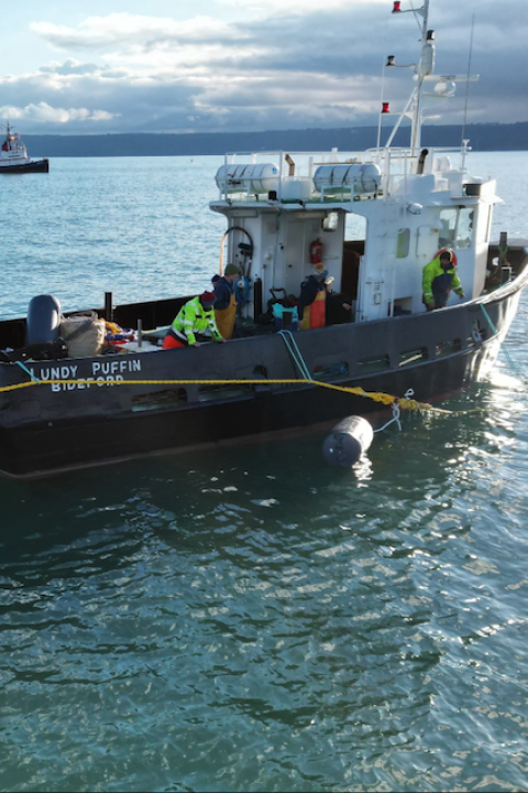 A ship named the Lundy Puffin placing ropes in the water to build the Blue Forest project farm — aquaculture