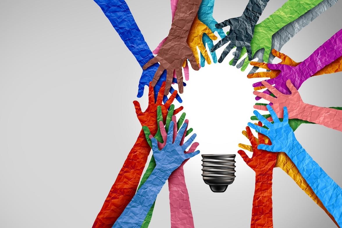 Hands reaching together to form the shape of a lightbulb — AI