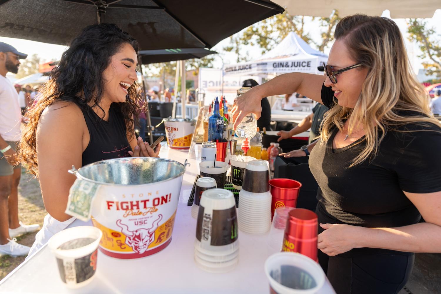 A bartender at a University of Southern California football game pours a drink into a Better for All cup. 