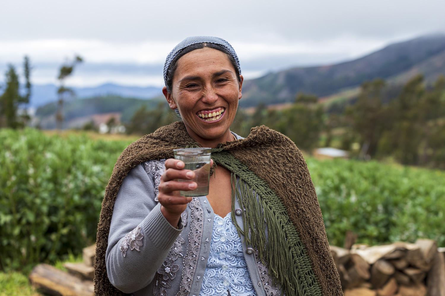 Bolivian Woman Holding Glass of Water - Access to Sanitation and Clean Water Through Humanity-Centric Innovation