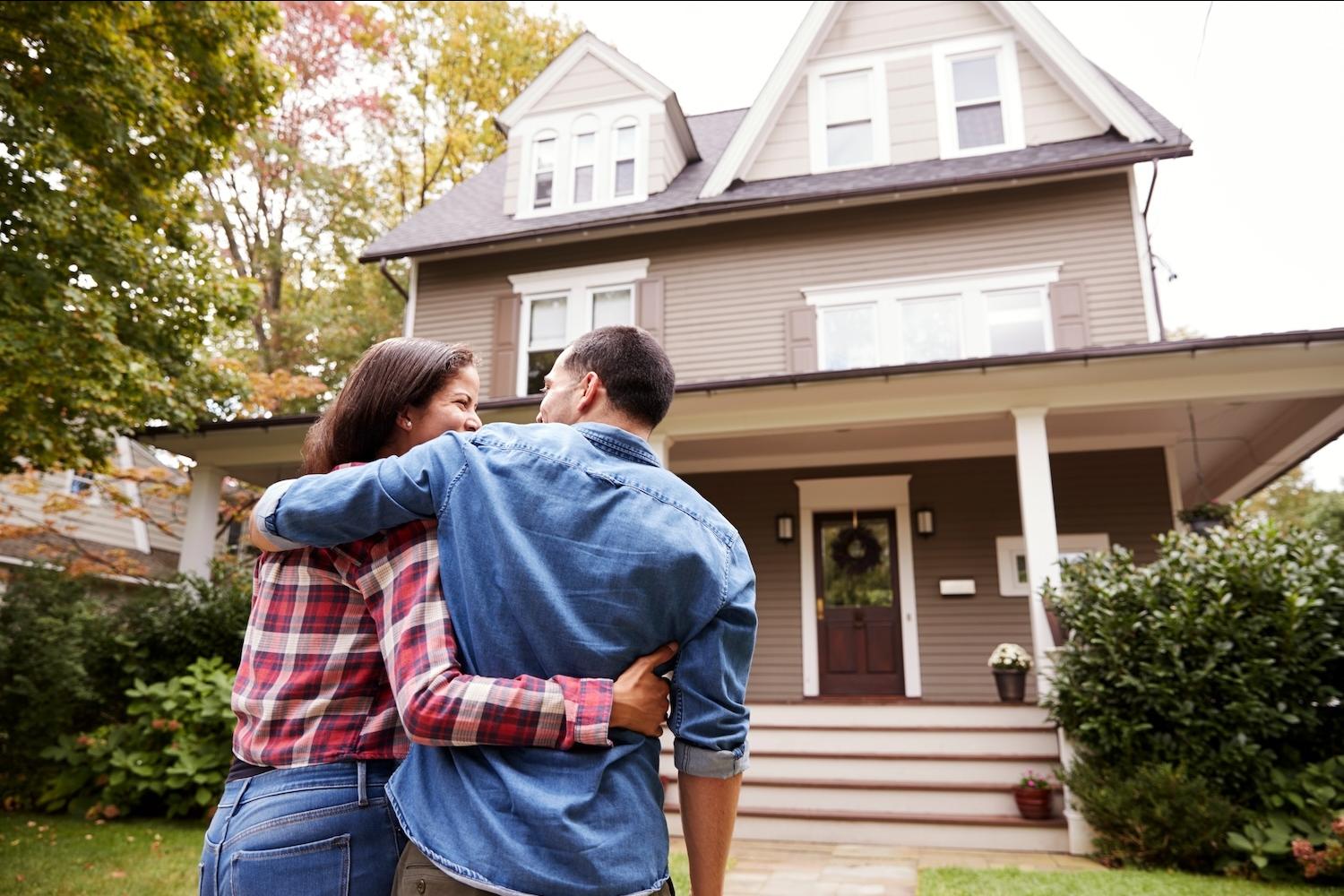 A couple standing together in front of a home — CDFIs