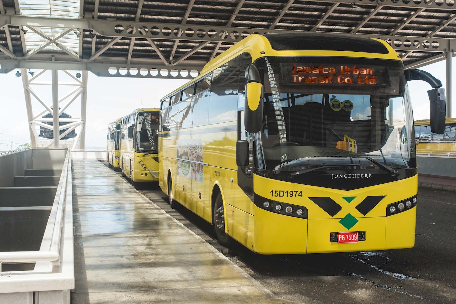 A yellow bus that's a part of the Jamaica Urban Transit Company fleet — CNG buses