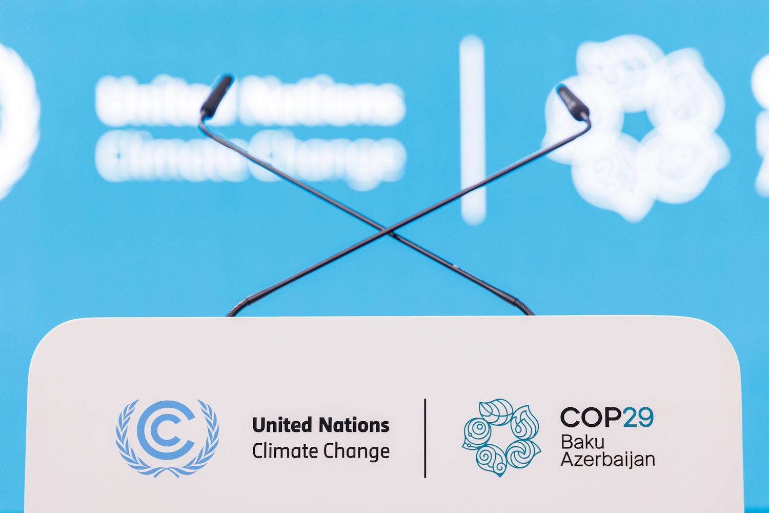 An empty podium with microphones at COP29.