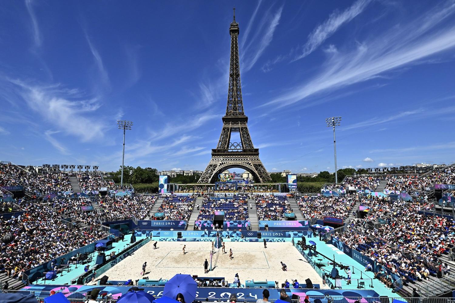 Paris Olympics 2024 — a crowd watches a womens volleyball match behind the eiffel tower