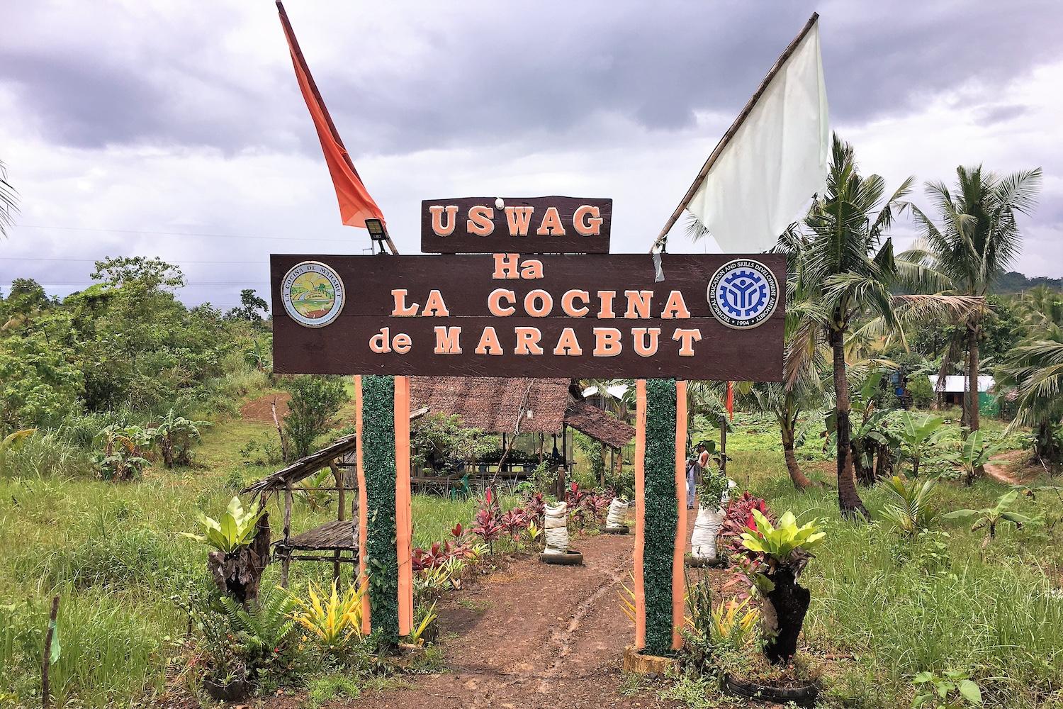 A wooden arch at the entrance to the agricultural cooperative La Cocina De Marabut, which advertises its name, in Barangay Osmeña, the Philippines.