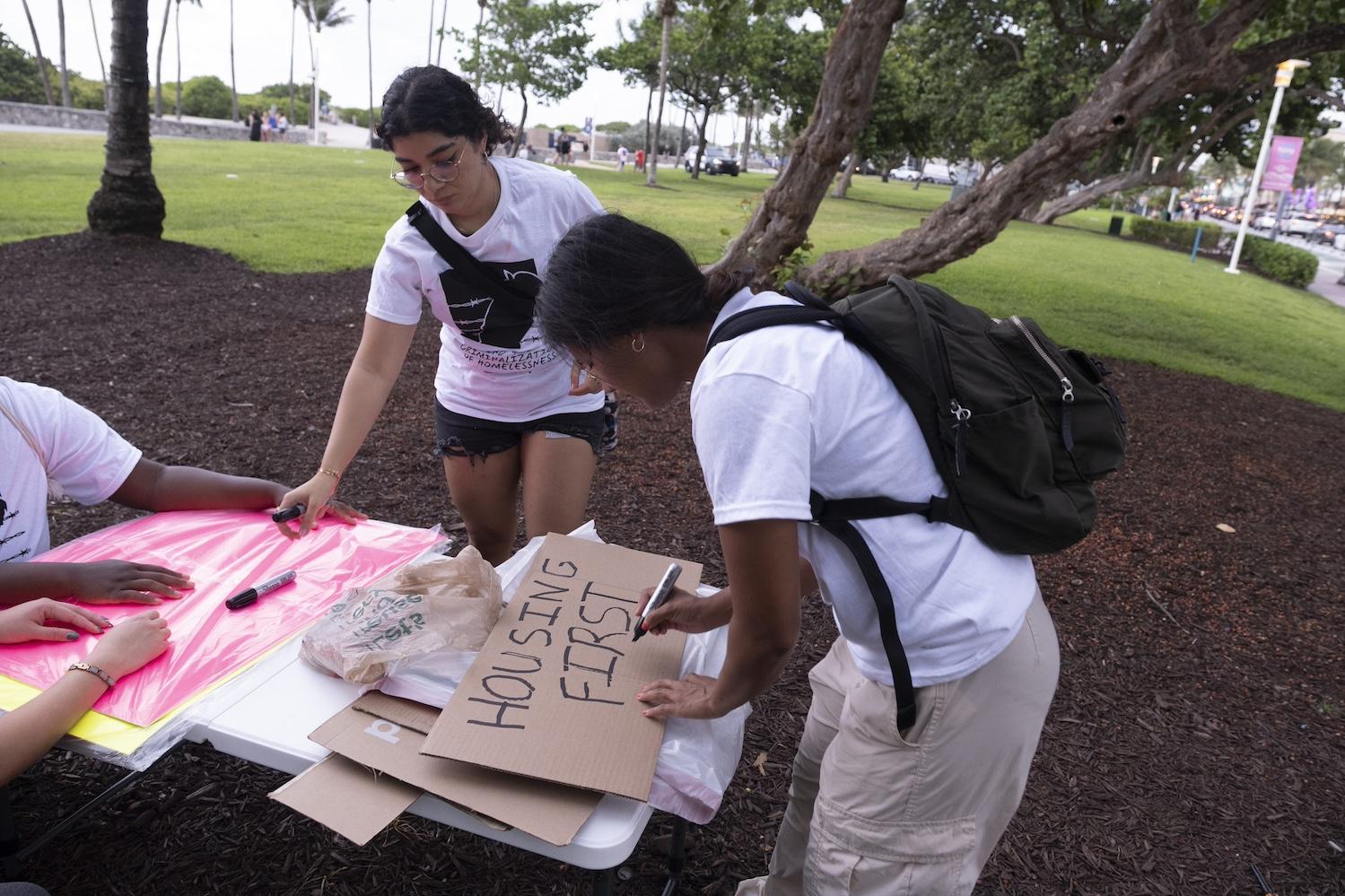 The SMASH team creates a sign that reads "housing first" — climate gentrification