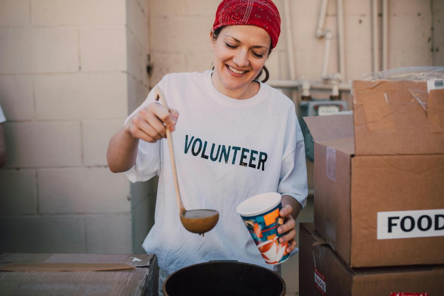 A volunteer serving soup — corporate giving