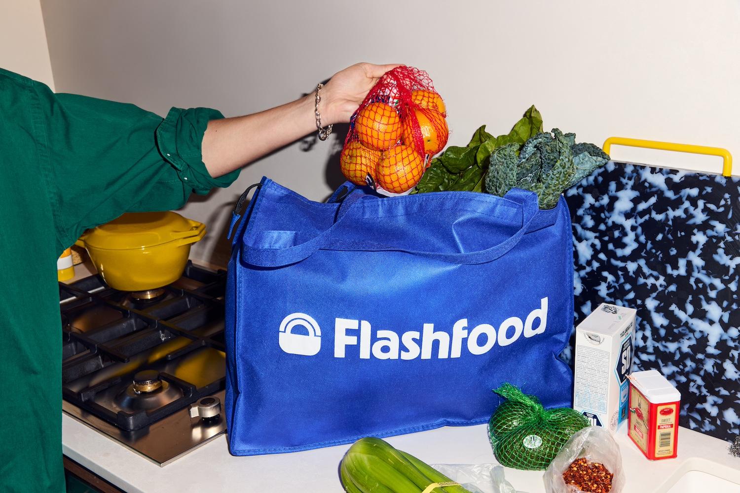 A person grabbing produce out of a bag from the food waste app Flashfood.