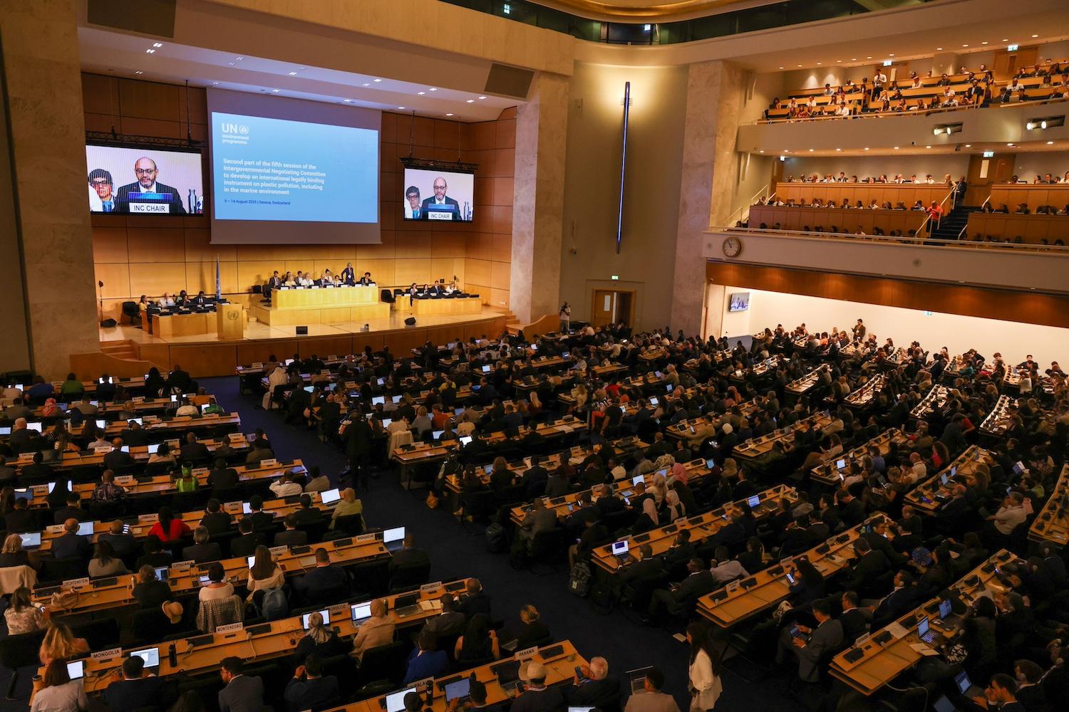 Negotiators sit in a large auditorium for the opening session of the negotiations for the global plastic pollution treaty.