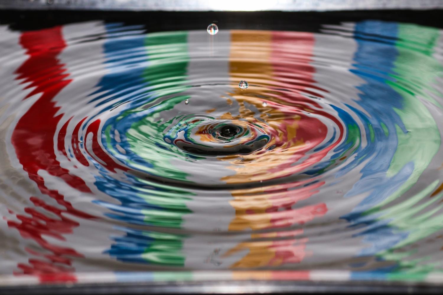 Droplet hitting water with rainbow