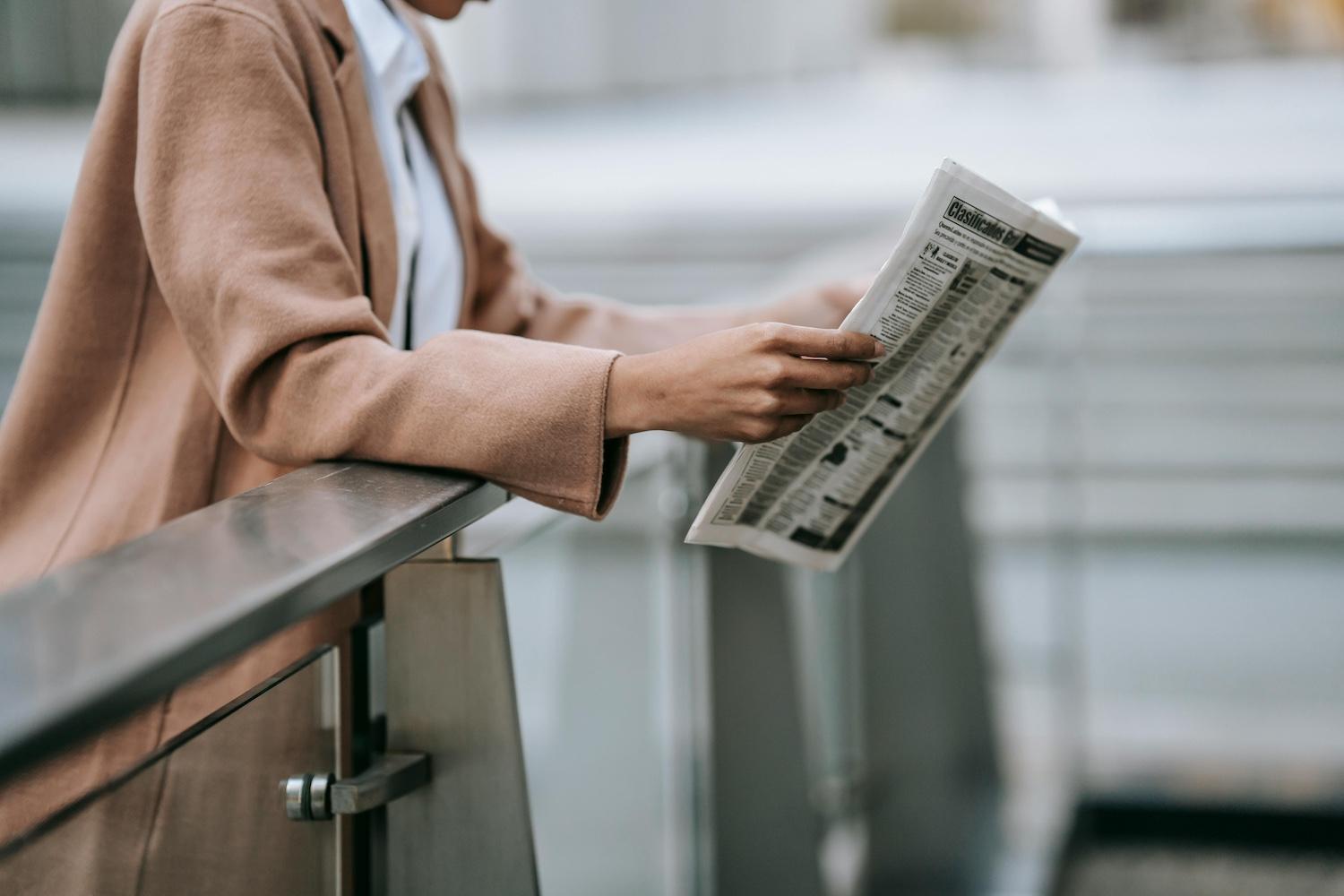 A person reading a newspaper. 