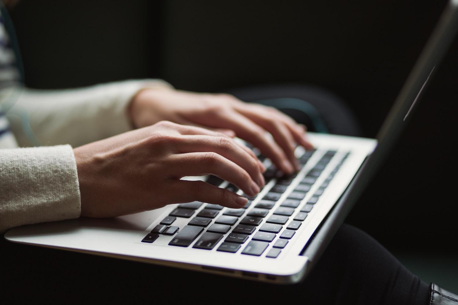 A person typing on a laptop. 