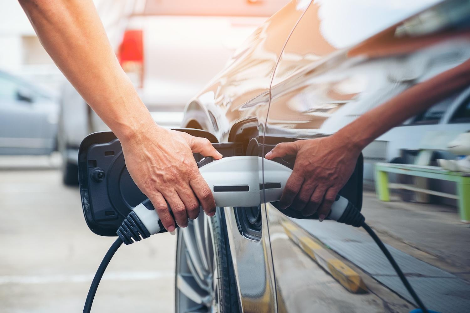 man charging an electric vehicle — EVs and the power grid 
