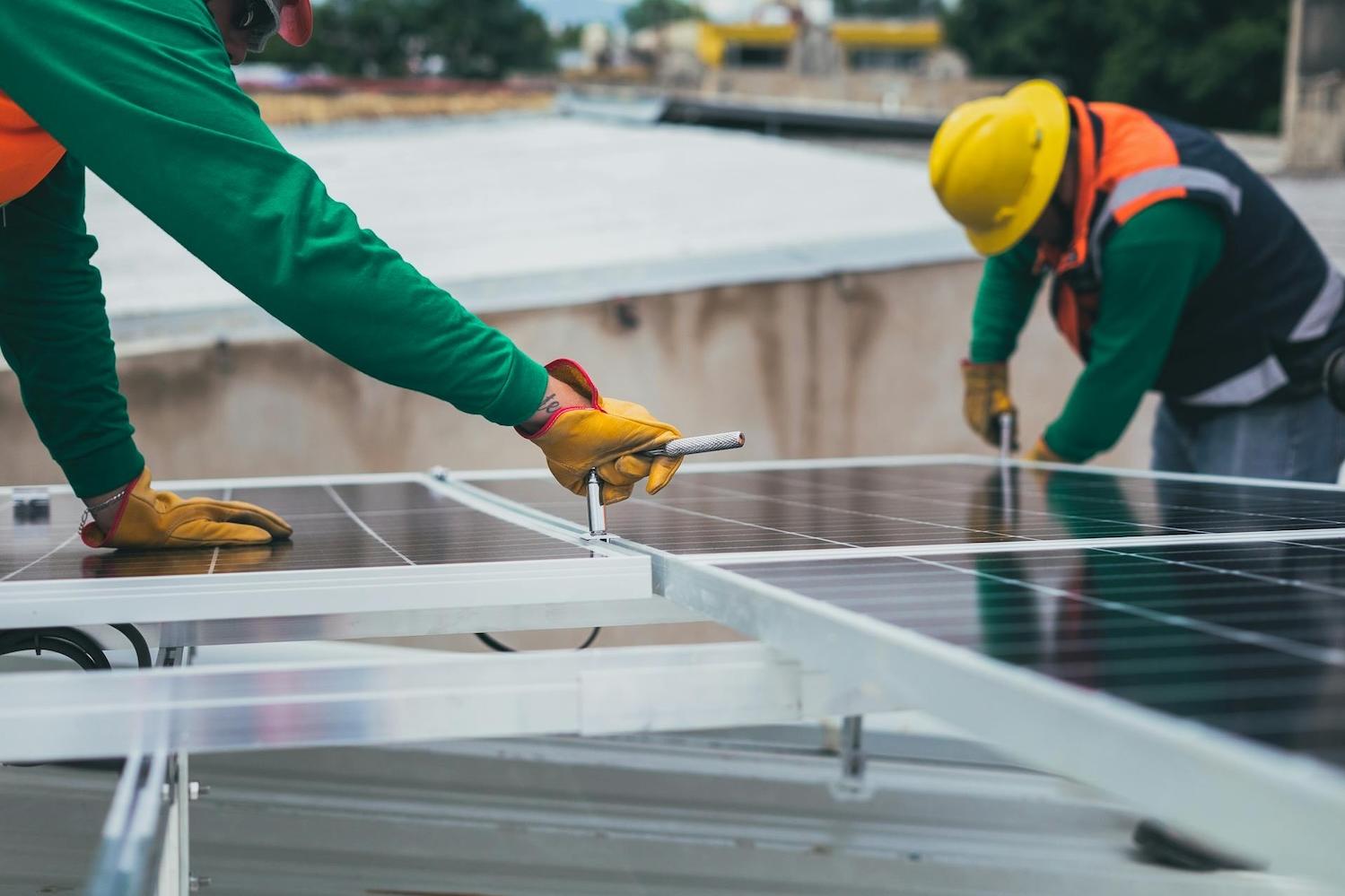 men installing solar panels on a roof