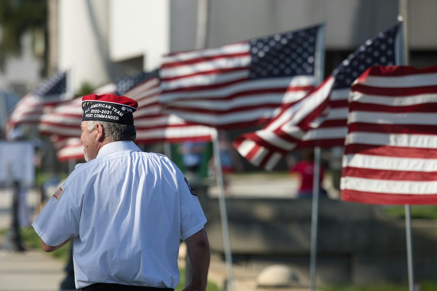 A United States veteran walks along a row of American flags — Mesothelioma