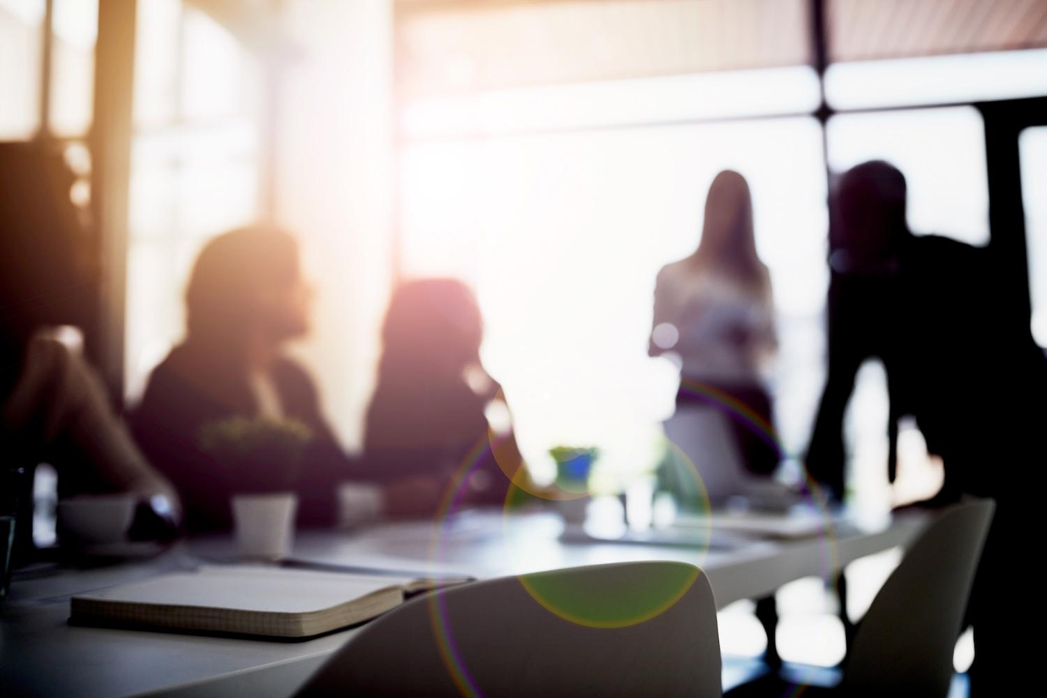 people talking in a board room — ESG is here to stay
