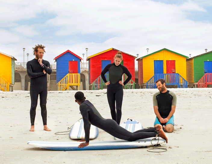 Travelers participate in a “Surf With Purpose” Social Impact Experience in Cape Town. Each lesson provides one month of surf therapy for a local child.