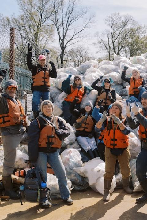 Members of the Alternative Spring Break Program pose with a pile of bagged trash.