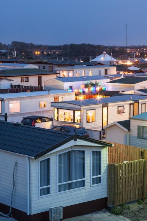 mobile homes in a mobile home park at sunset - mobile home owners are forming mobile home co-ops for climate resilience