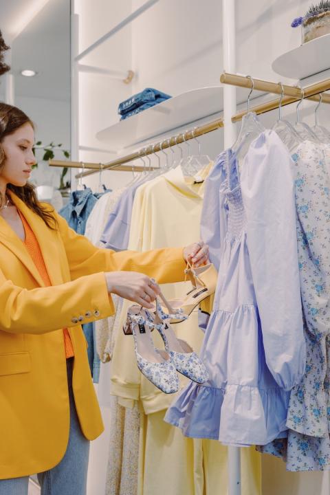 woman shopping for clothing and shoes in a retail store - how retailers can combat greenwashing