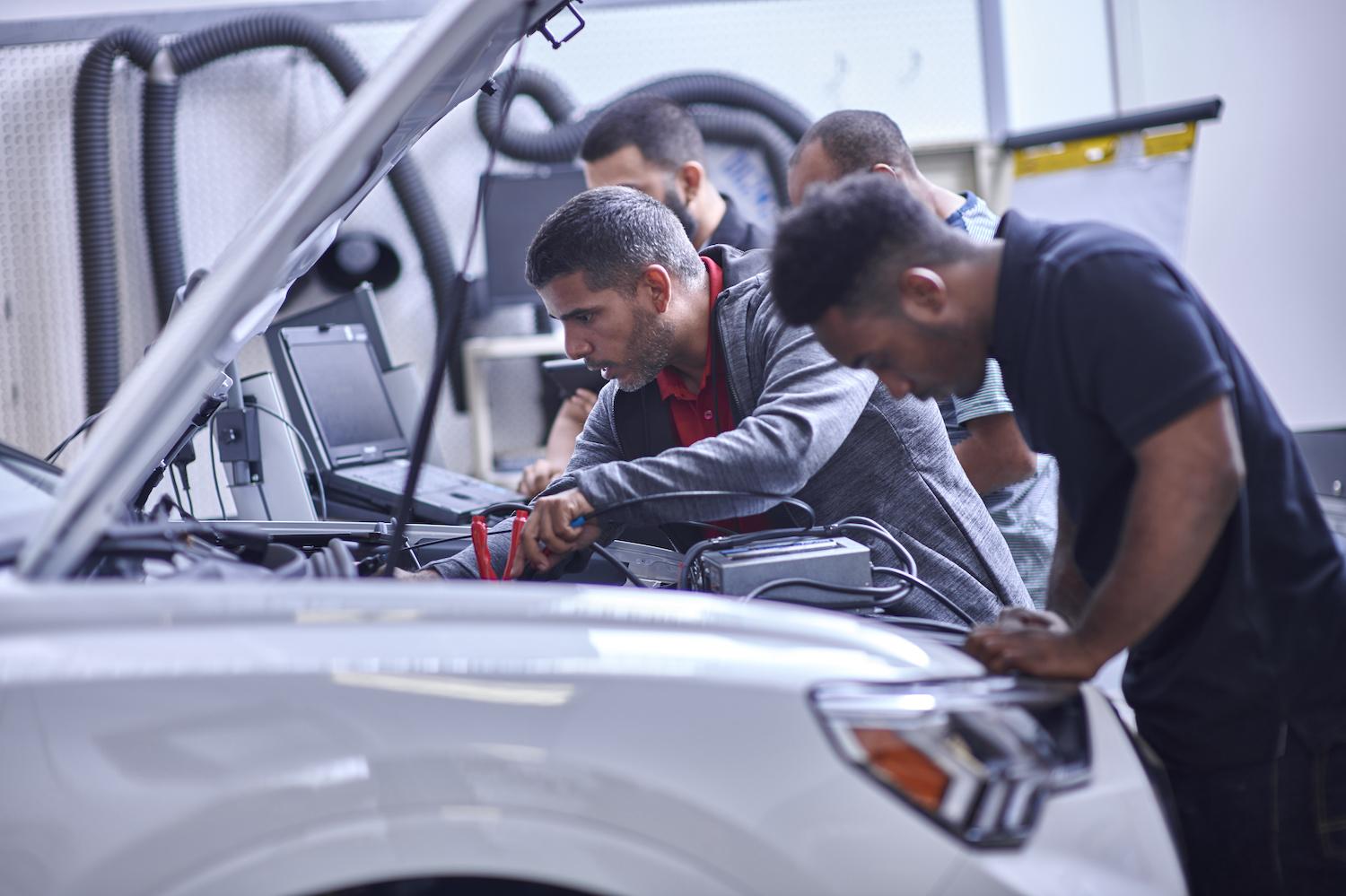Students working on vehicles as a part of the Audi Education Partnership. 