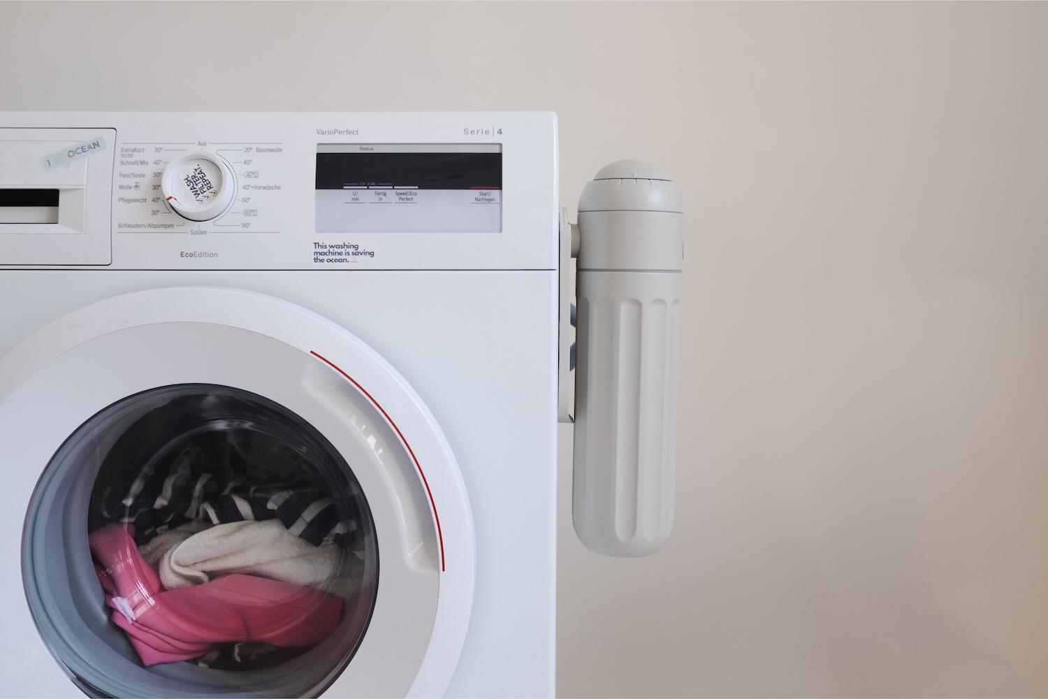PlanetCare's microfiber filter attached to the side of a laundry machine.