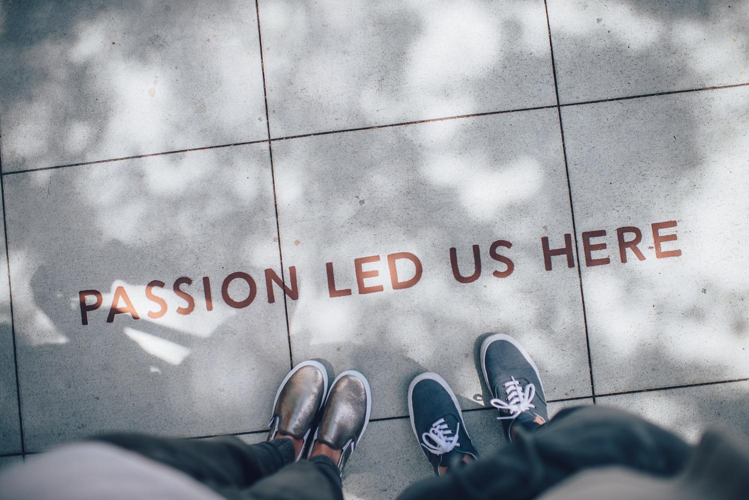 A photo looking down at two pairs of shoes and the words "Passion Led Us Here".